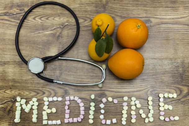 fonendoscopio, dos limones, dos naranjas con la palabra: MEDICINA
. - Foto, Imagen
