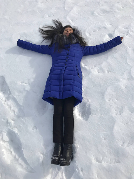 Жінка лежить на снігу
  - Фото, зображення