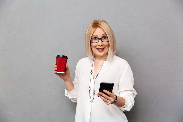 Surprised middle-aged blonde woman in shirt and eyeglasses - Valokuva, kuva