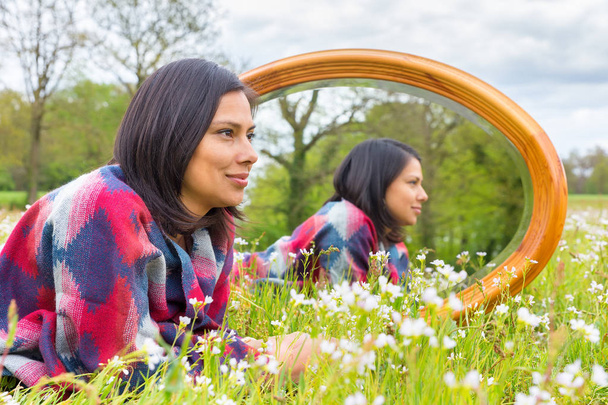 Femme couchée dans une prairie fleurie avec miroir
 - Photo, image