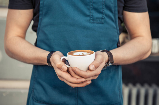 Barista, trzymając kubek kawy latte art - Zdjęcie, obraz