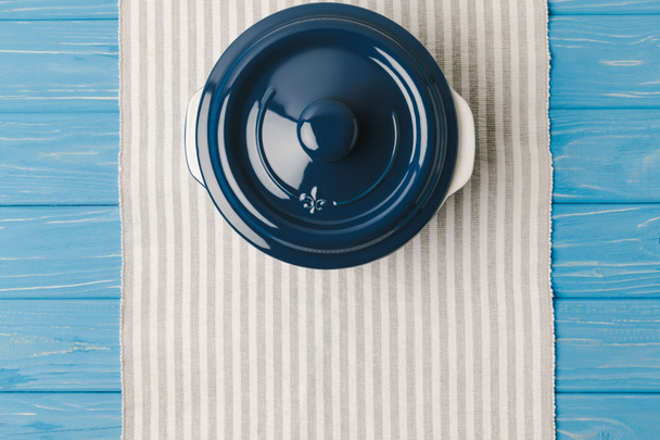 top view of pan on napkin on blue wooden table - Fotoğraf, Görsel