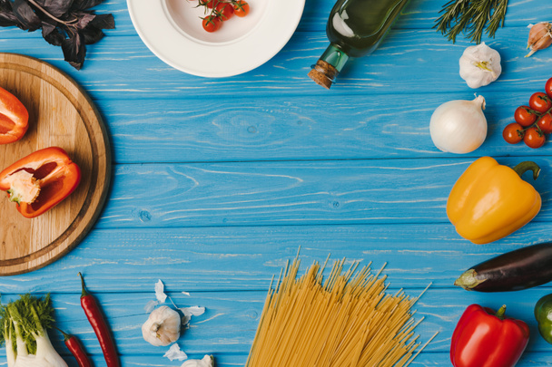 top view of blue table with pasta ingredients  - Φωτογραφία, εικόνα