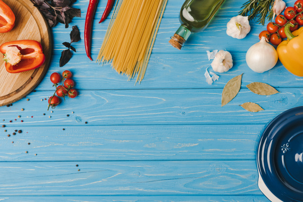 vista superior de los ingredientes para cocinar pasta en la mesa azul
 - Foto, Imagen
