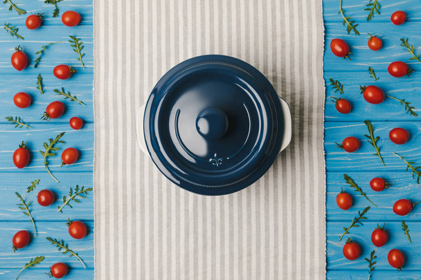 vista superior de tomates cherry con rúcula y sartén en servilleta
 - Foto, Imagen
