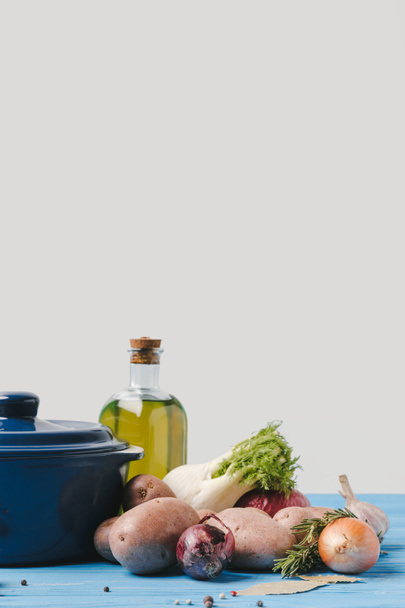 pan with ripe organic vegetables and olive oil on table in kitchen - Fotoğraf, Görsel
