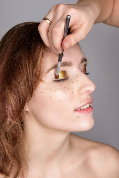 Woman a freckle golden tears on the face. - Фото, зображення