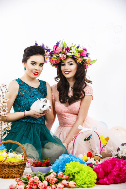 Two beautiful women playing in easter decoration with a rabbit.  - Foto, Imagem