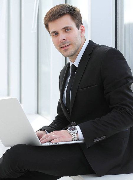young professional with laptop on background of office window - Foto, Imagen