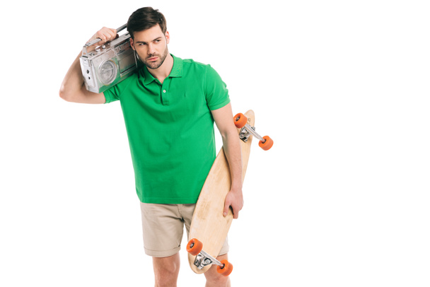 handsome young man holding skateboard and tape recorder isolated on white   - Photo, Image