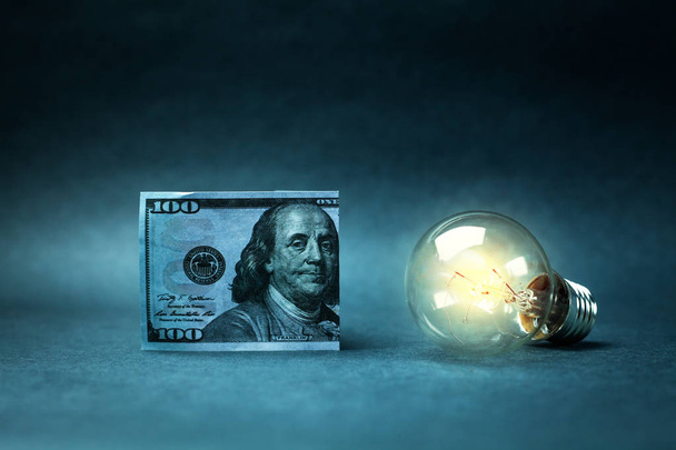 Hundred dollar and light bulb. Concept of idea and wealth. - Fotoğraf, Görsel