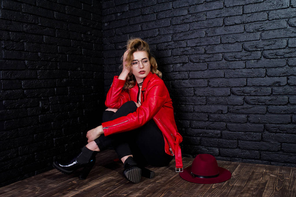 Studio portrait of blonde girl with red hat, glasses and leather - Foto, imagen