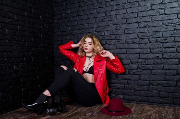 Studio portrait of blonde girl with red hat and leather jacket p - Foto, afbeelding