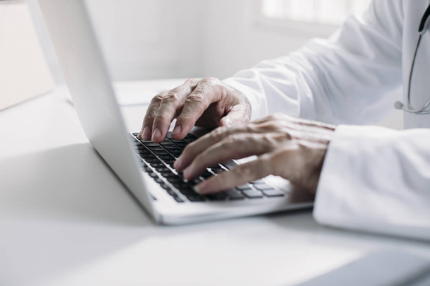 Um médico digitando no laptop
 - Foto, Imagem