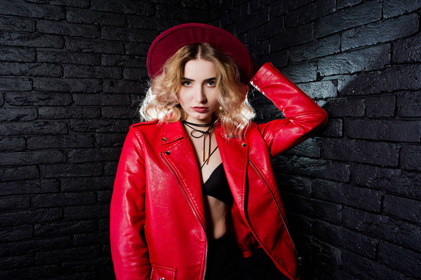 Studio portrait of blonde girl in red hat and leather jacket aga - Фото, изображение