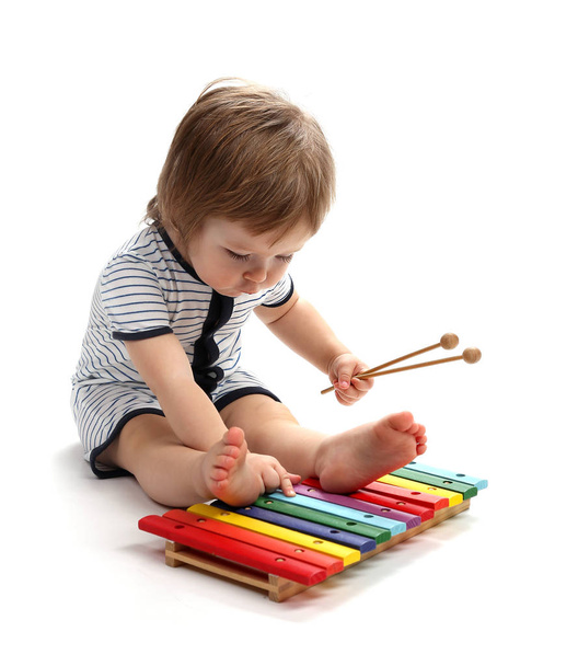 Beautiful baby 1.5 years studying xylophone. Isolated on a white background. - 写真・画像