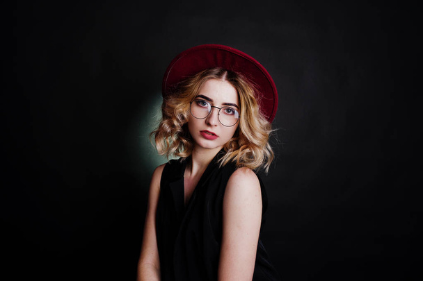 Studio portrait of blonde girl in black wear, red hat and glasse - Фото, зображення
