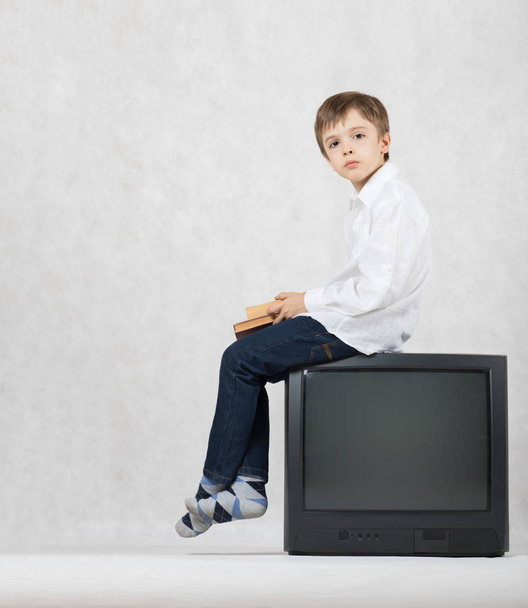 Jongen van zeven jaar oud en een oude Tv. vrije ruimte voor een tekst. - Foto, afbeelding