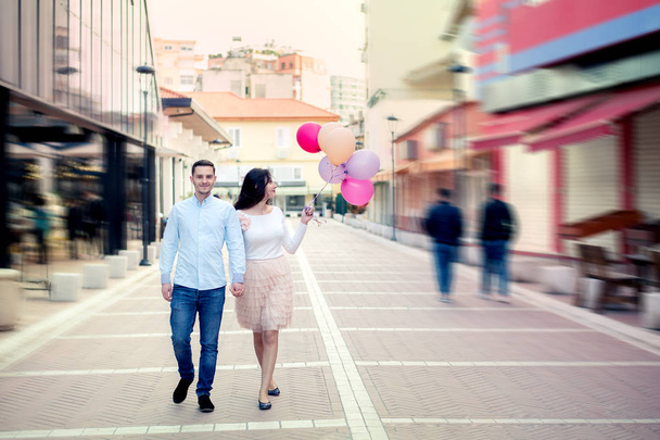 Happy couple walking with balloons in central street of Tirana, Albania, at the New Bazaar, or Pazari i ri - Fotó, kép