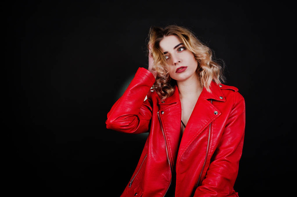 Studio portrait of blonde girl in red leather jacket against bla - Zdjęcie, obraz