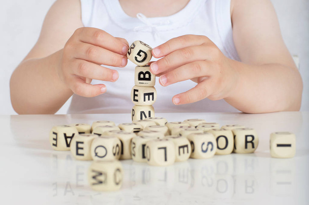 Mała dziewczynka dwóch lat komponuje słów z liter. Zbliżenie - Zdjęcie, obraz