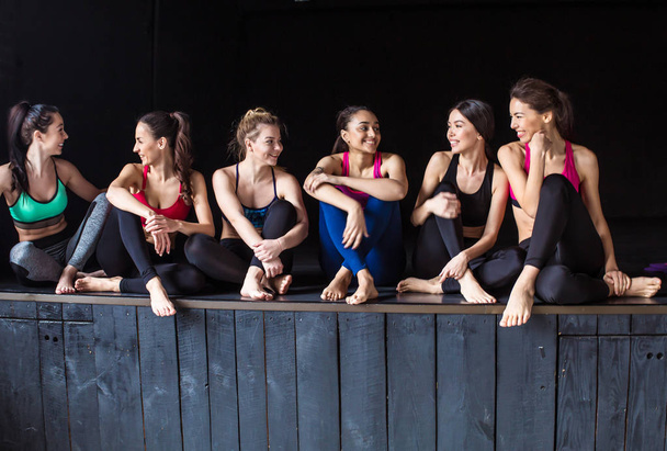 Smiling girlfriends. Happy and cheerful group of young beautiful girls in sports clothing for training, rest after fitness exercise or yoga or after dancing. - Foto, imagen