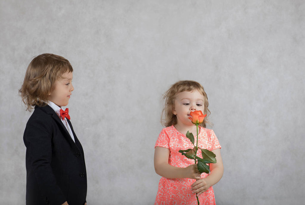 Αγόρι τεσσάρων ετών παρουσιάζει ένα τριαντάφυλλο για το κορίτσι - Φωτογραφία, εικόνα