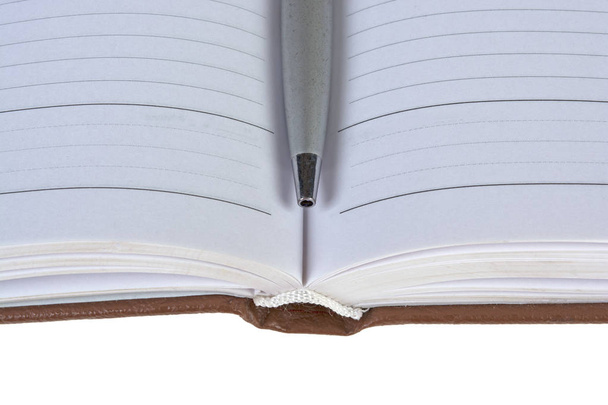 avoin päiväkirja ja kynä valkoisella taustalla
 - Valokuva, kuva