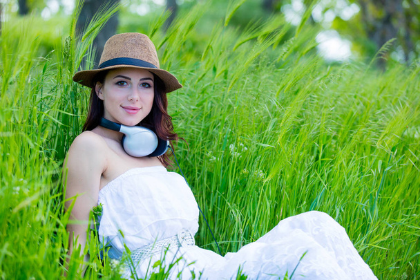Piękna dziewczyna z słuchawki w polu pszenicy w sezonie letnim - Zdjęcie, obraz