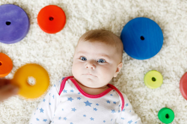 Cute baby girl playing with colorful wooden rattle toy - Фото, зображення