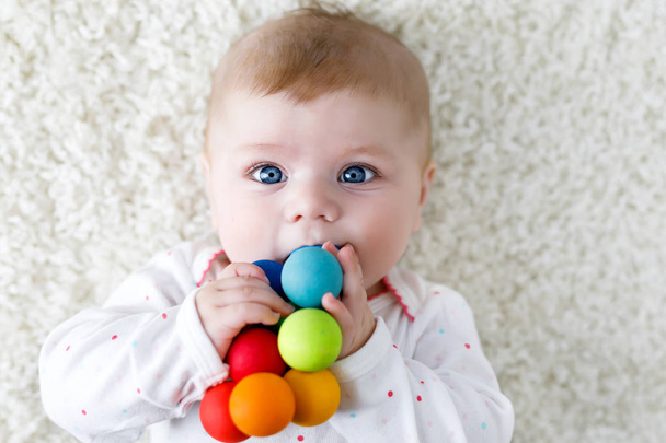 Carino bambino ragazza che gioca con colorato giocattolo sonaglio di legno
 - Foto, immagini