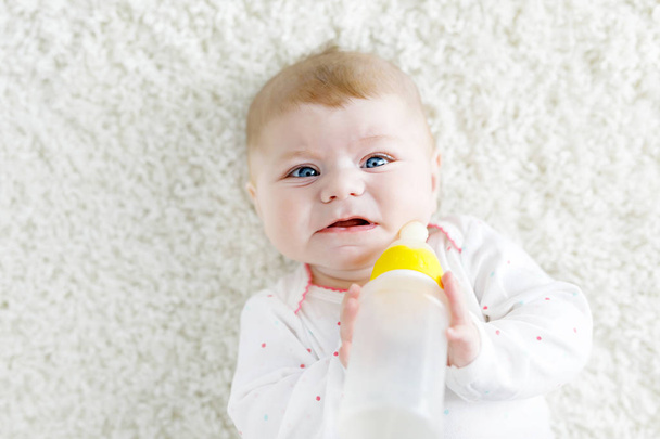 Niedliche entzückende ewborn Baby Mädchen hält Stillflasche und trinkt Formel Milch - Foto, Bild