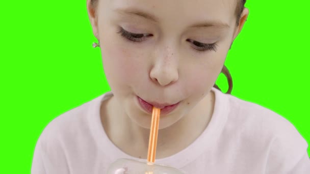Nice girl drinking through a straw drink. Green screen - Materiał filmowy, wideo