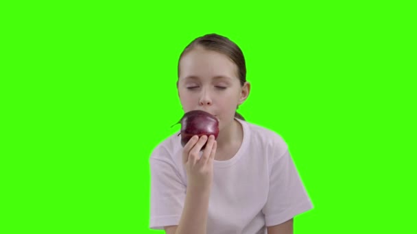 9 year old girl portrait eating red apple outdoor - Materiał filmowy, wideo