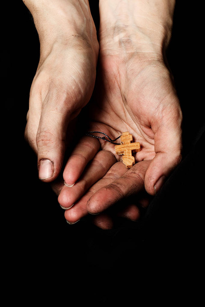 Wooden handmade cross in the palm of a peasant woman.  - Photo, Image