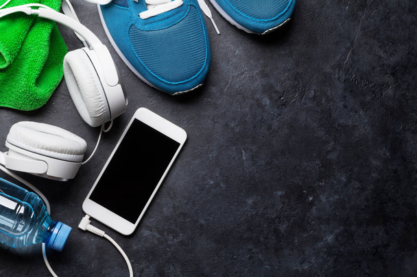 Fitness konsepti tausta lenkkarit, kuulokkeet, älypuhelin, vesipullo ja pyyhe. Top näkymä tilaa tekstin
 - Valokuva, kuva
