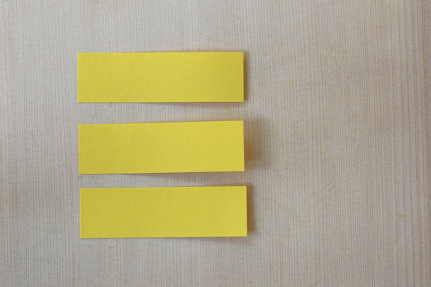 Lápiz verde que apunta a la nota de papel amarillo vacío en ba piso de madera
 - Foto, Imagen