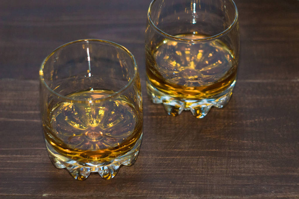 Een glas whiskey close-up. Kijk onder een hoek. - Foto, afbeelding