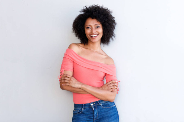 Ritratto di attraente donna africana sorridente in piedi su sfondo bianco con le braccia incrociate
 - Foto, immagini