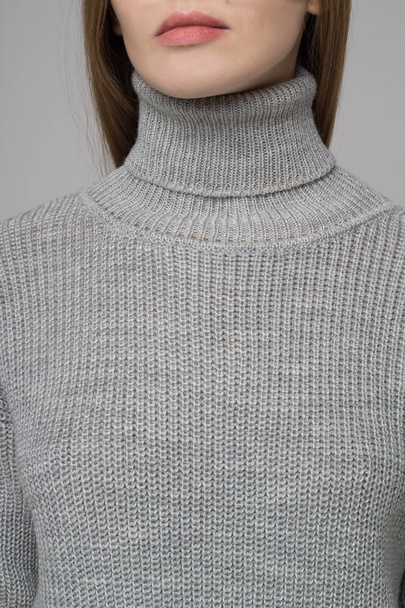 Close-up of female model corpus in grey knitted dress - Foto, afbeelding