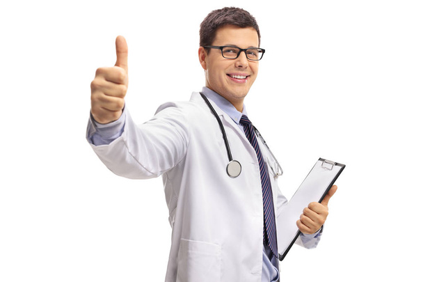 Doctor with a clipboard making a thumb up gesture isolated on white background - Foto, afbeelding
