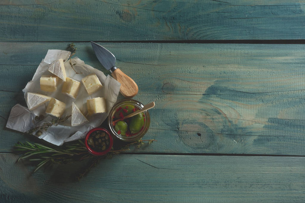 camembert cheese slices and nuts on blue wooden background, top view with copy space - Valokuva, kuva