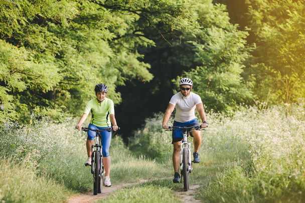 bir kadın ve bir adam parkta yaz aylarında Bisiklet Bisiklete binme - Fotoğraf, Görsel