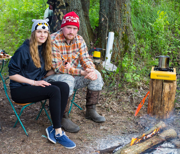 Šťastný pár sezení venkovní u táborového ohně, vaření kávy v har - Fotografie, Obrázek