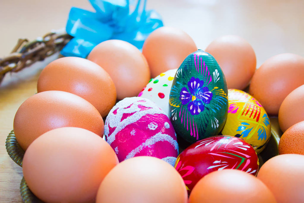 Природные и вручную окрашенные пасхальные яйца на круглом подносе
 - Фото, изображение