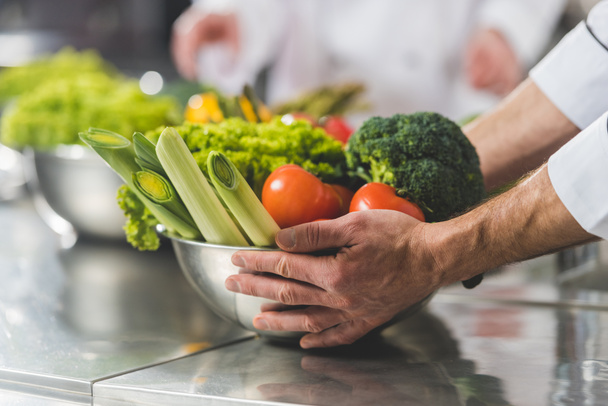 cropped image of chef taking bowl with vegetables at restaurant kitchen - Photo, Image