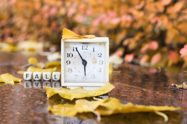 Antiguo reloj despertador cuadrado sobre una piedra de mármol cubierta por la lluvia
. - Foto, imagen