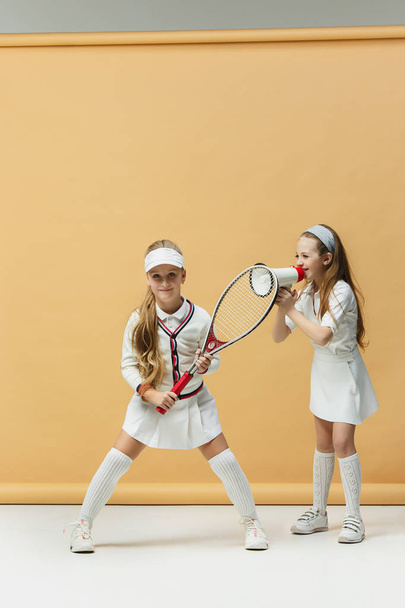 Portrait of two girls as tennis players holding tennis racket. Studio shot. - Fotó, kép