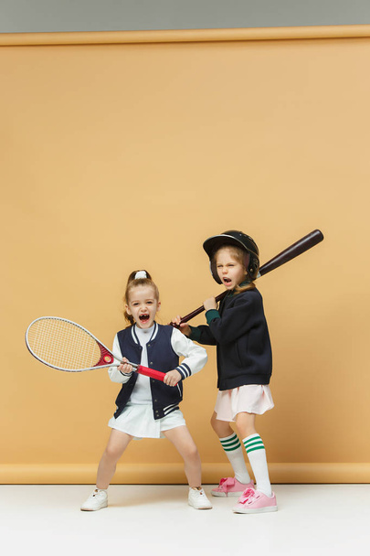 Portrait of two girls as tennis players holding tennis racket. Studio shot. - Фото, изображение