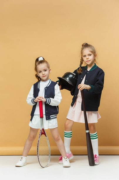 Portrait of two girls as tennis players holding tennis racket. Studio shot. - Photo, image